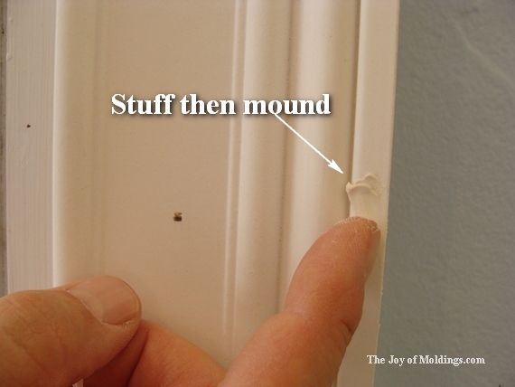 Scrape away the extra spackling that won't affect the nail hole you're